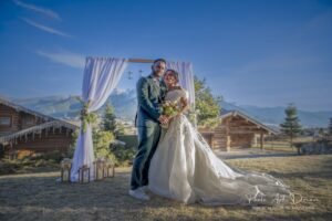 Mariage au grand air à Formiguères : les mariés posent devant une arche fleurie.