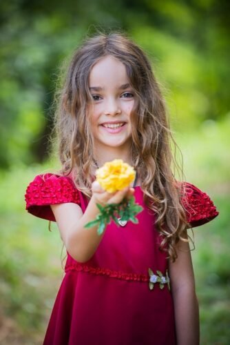 Portrait d’enfant en robe rouge dans un parc à Thuir