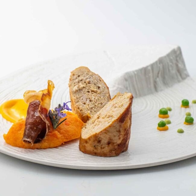 Tournedos, patate douce et pain tranché sur assiette blanche.