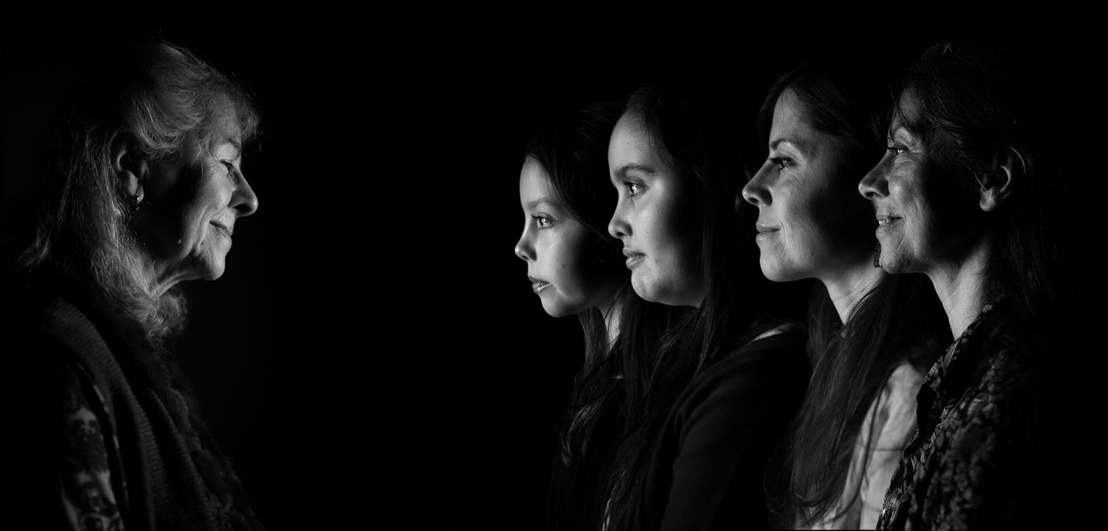 Portrait artistique de trois femmes de profil sur fond noir.