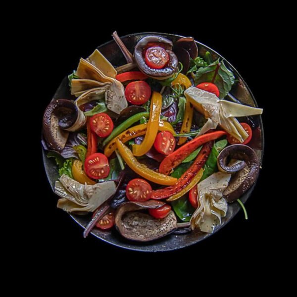 Poêlée de légumes frais aux couleurs vives sur fond noir.